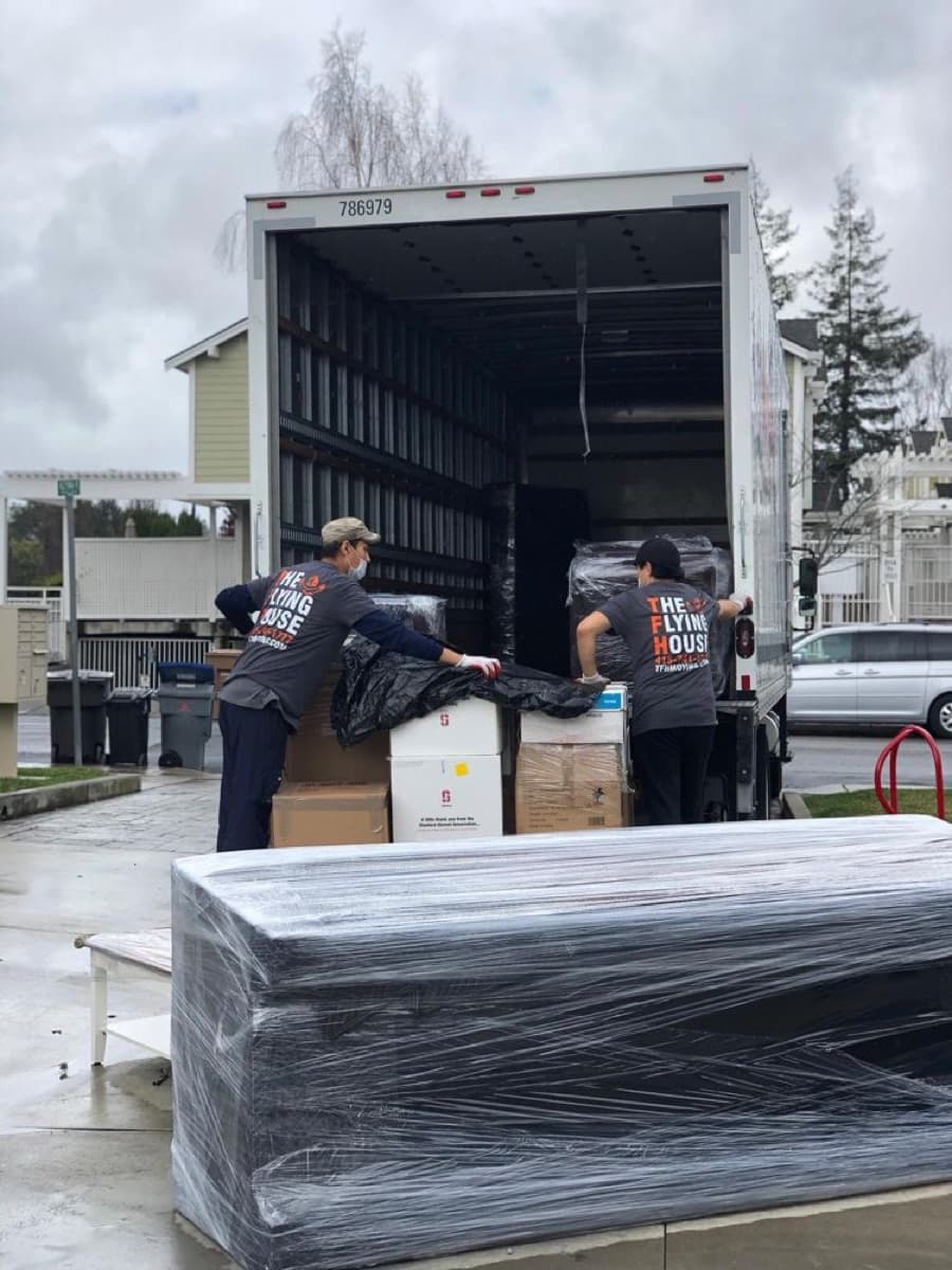 TFH movers loading wrapped furniture into a truck